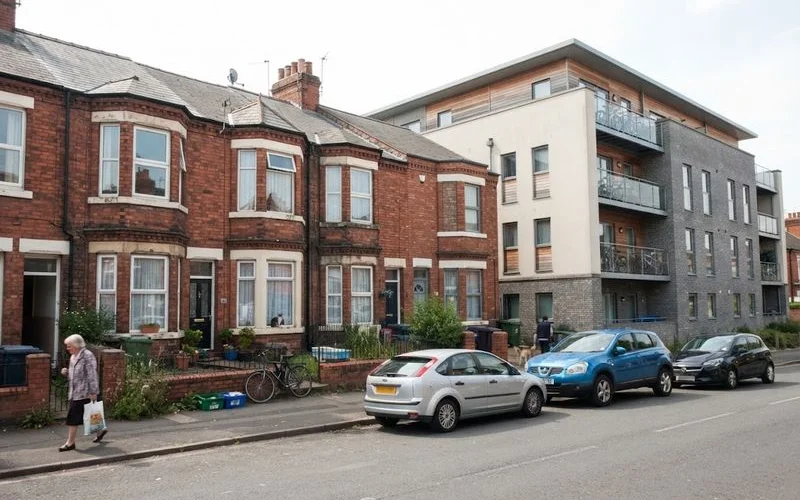A row of terraced houses next to a modern flat development in Birmingham, illustrating different property tenures