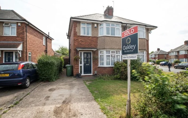 A "Sold" sign attached below a "For Sale" board outside a Birmingham house